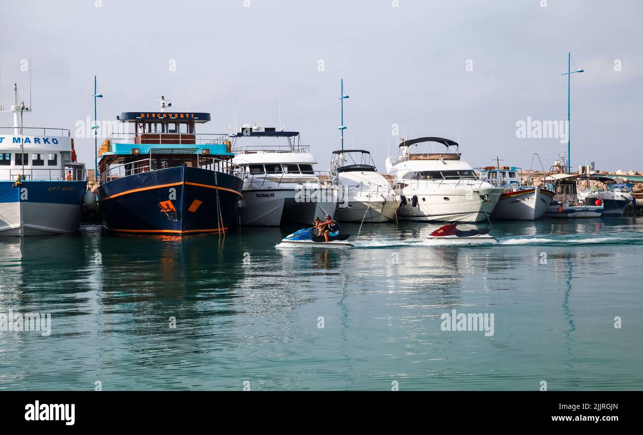 Ayia Napa, Cipro - 16 giugno 2018: Un uomo con un cane naviga al mattino sul porto di Agia Napa Foto Stock