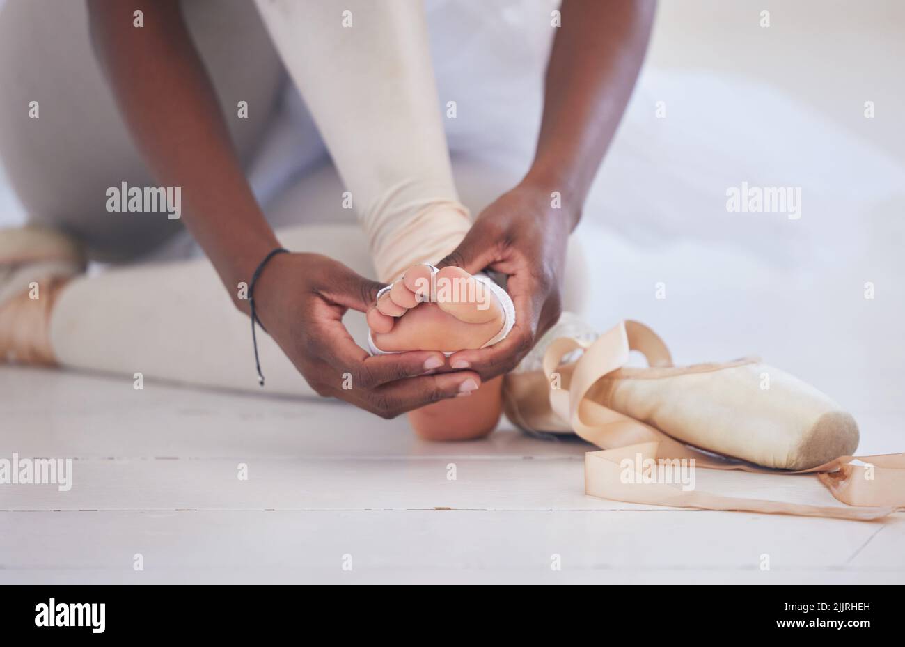 Eppure, balliamo sopra. Una ballerina di balletto irriconoscibile che lega sulle sue scarpe pointe. Foto Stock