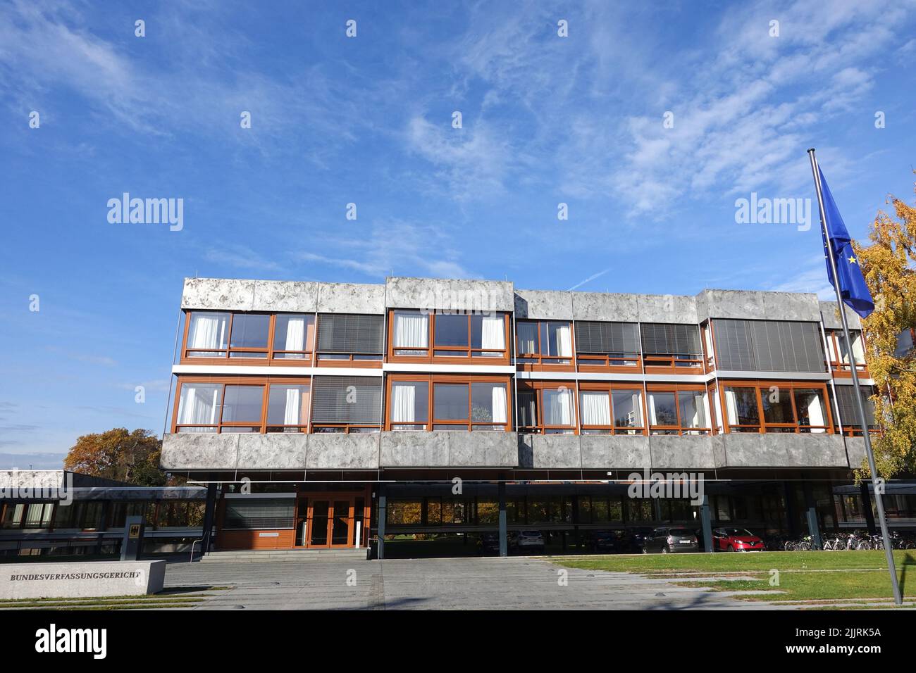 Il design esterno della costruzione della corte costituzionale federale di Germania con albero e bandiera blu nel cortile di fronte Foto Stock