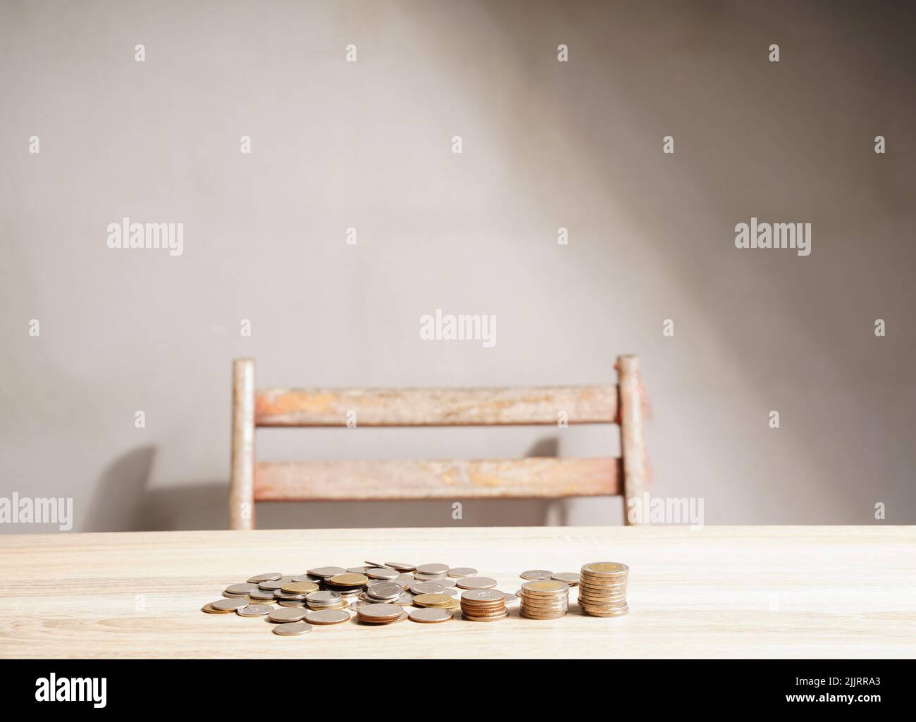 Monete impilate su un astratto tavolo d'annata. Idee di risparmio per investimenti economici, crescita stabile e risparmio per la pensione. Foto Stock