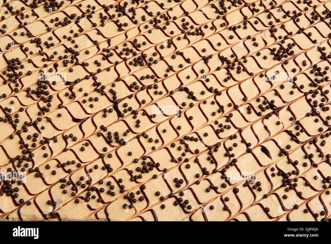 Un primo piano con dettagli di una fetta di torta quadrata con linee di cioccolato bianco e cioccolato nero Foto Stock