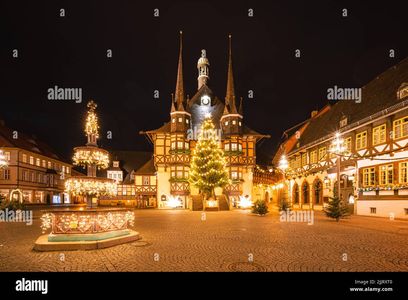 Wernigerode mercatino di Natale di notte. Luci di Natale e fontana Foto Stock