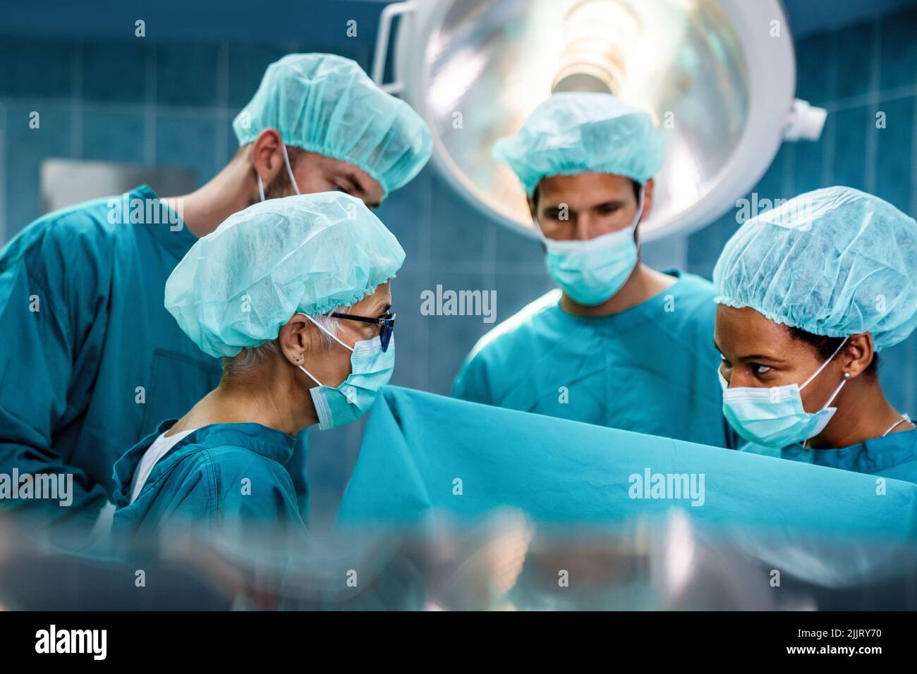 Gruppo di chirurghi in esercizio in sala operatoria presso l'ospedale. Chirurgia, medicina e concetto di persone Foto Stock
