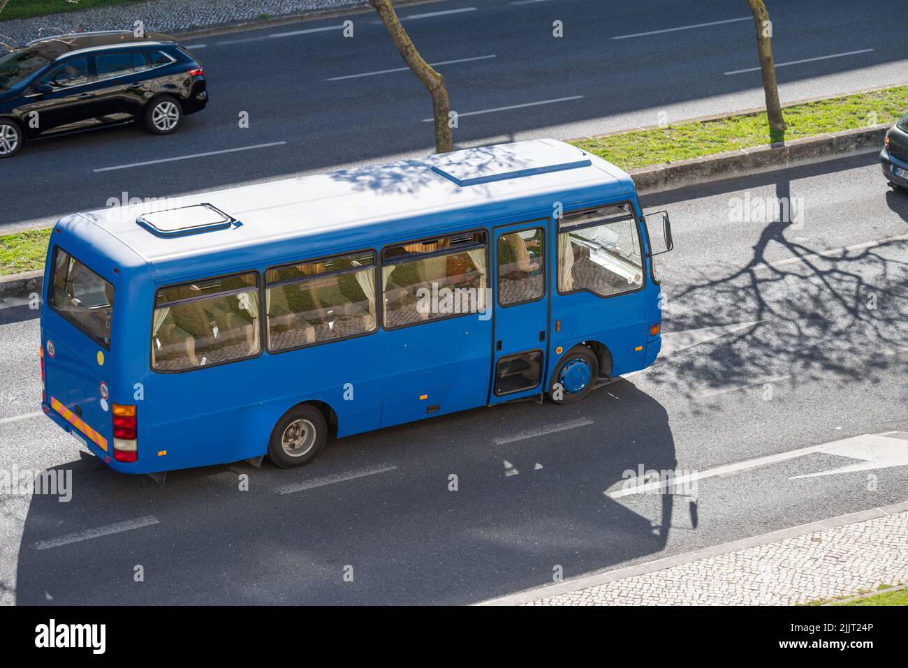 Una foto panoramica di un mini bus blu con i passeggeri nelle strade di Lisbona, Portogallo Foto Stock