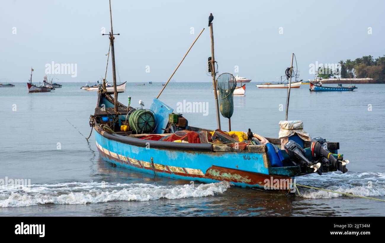 Una vecchia barca d'epoca piena di oggetti antichi galleggianti sul mare. Foto Stock