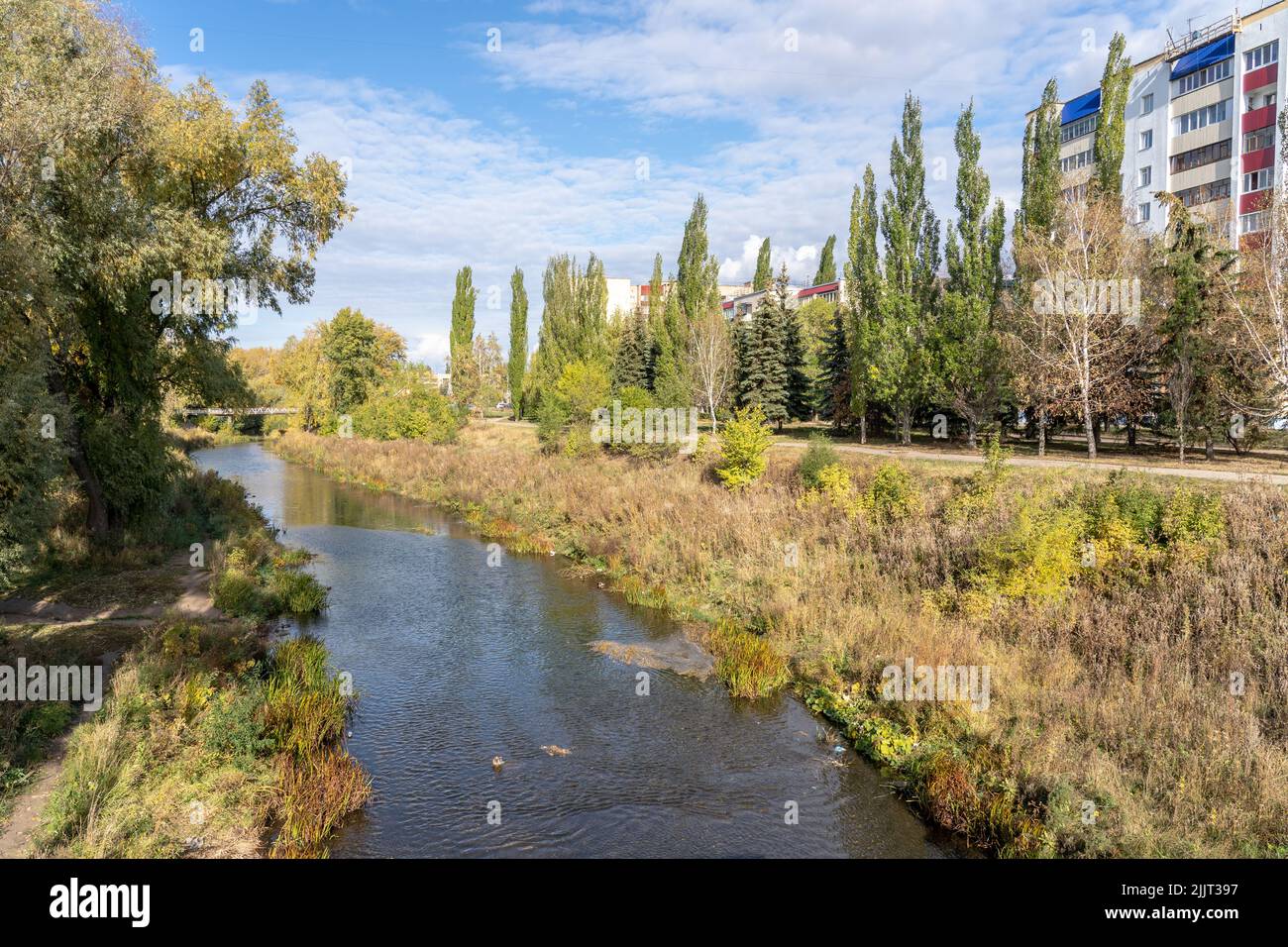 Paesaggio autunnale. Ponte sul fiume all'interno della città di Sterlitamak, Repubblica di Bashkortostan. Il fogliame dorato cresce sulla riva, sotto il cielo blu Foto Stock