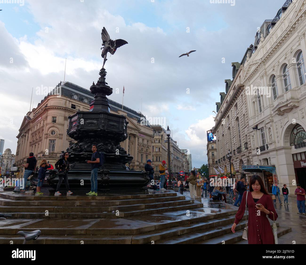 Londra, Greater London, Inghilterra, giugno 30 2022: Folle intorno alla Shaftesbury Memorial Fountain aka Eros dopo la pioggia in Piccadilly Circus. Foto Stock