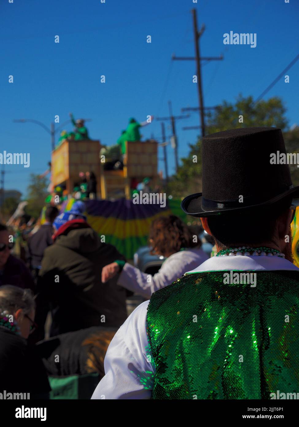 Un colpo posteriore di un uomo vestito di verde e bianco guarda l'irlandese Channel St. Patrick's Day Parade a New Orleans, Stati Uniti Foto Stock