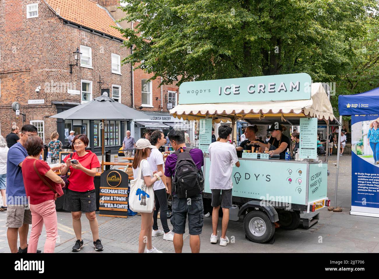 Il fornitore di gelati si è bloccato con una coda di clienti in una giornata calda nella città di York, Yorkshire, Inghilterra, Regno Unito Foto Stock