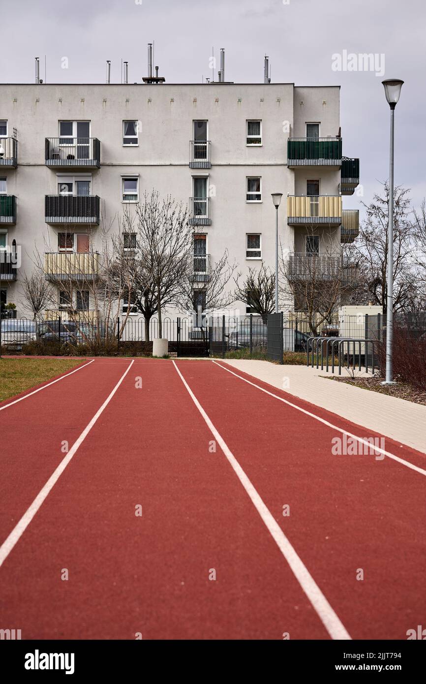 Una pista da primo piano di un campo sportivo che conduce ad un edificio di appartamenti nel quartiere di stare Zegrze. Foto Stock