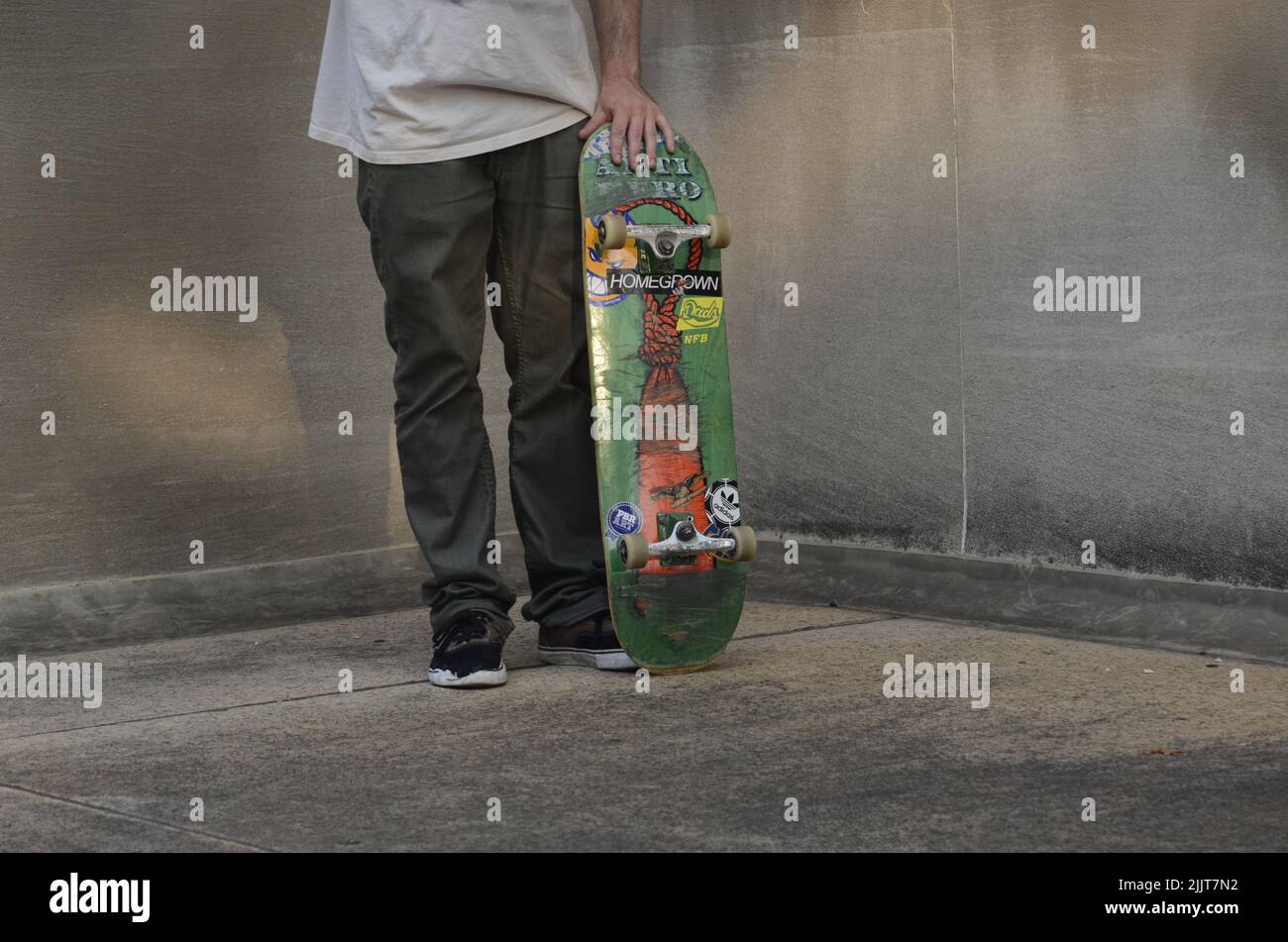 Un ragazzo skater con il suo skateboard all'aperto Foto Stock