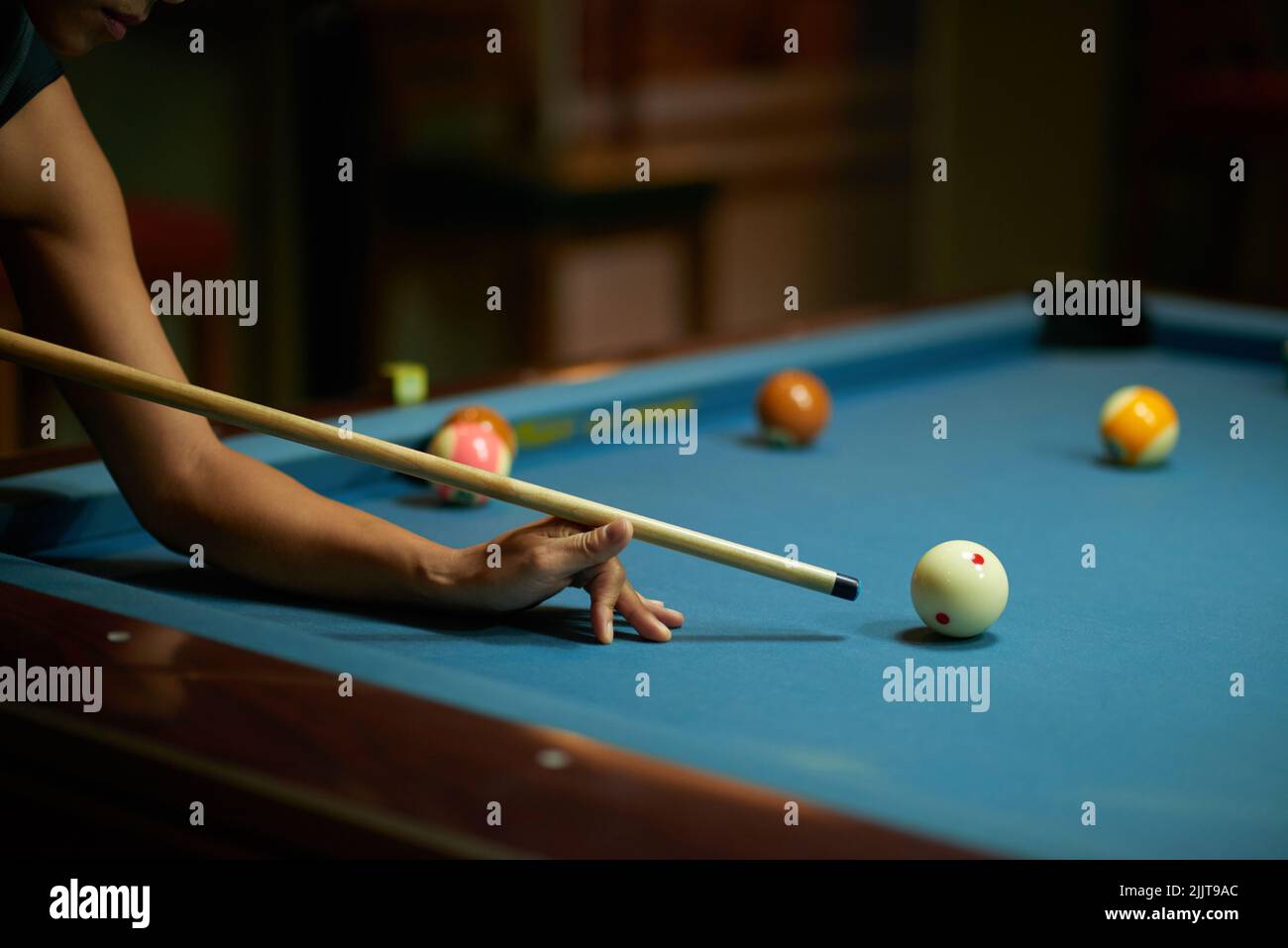 Immagine ritagliata del giocatore che colpisce la palla con un cue Foto Stock