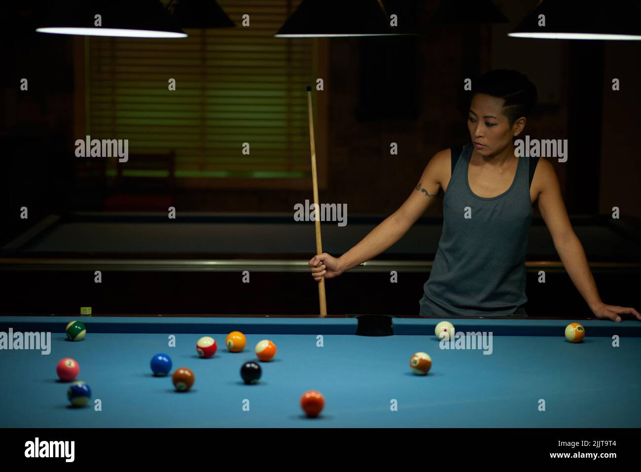 Giocatore di snooker femminile che medita sulla sua strategia per il gioco Foto Stock