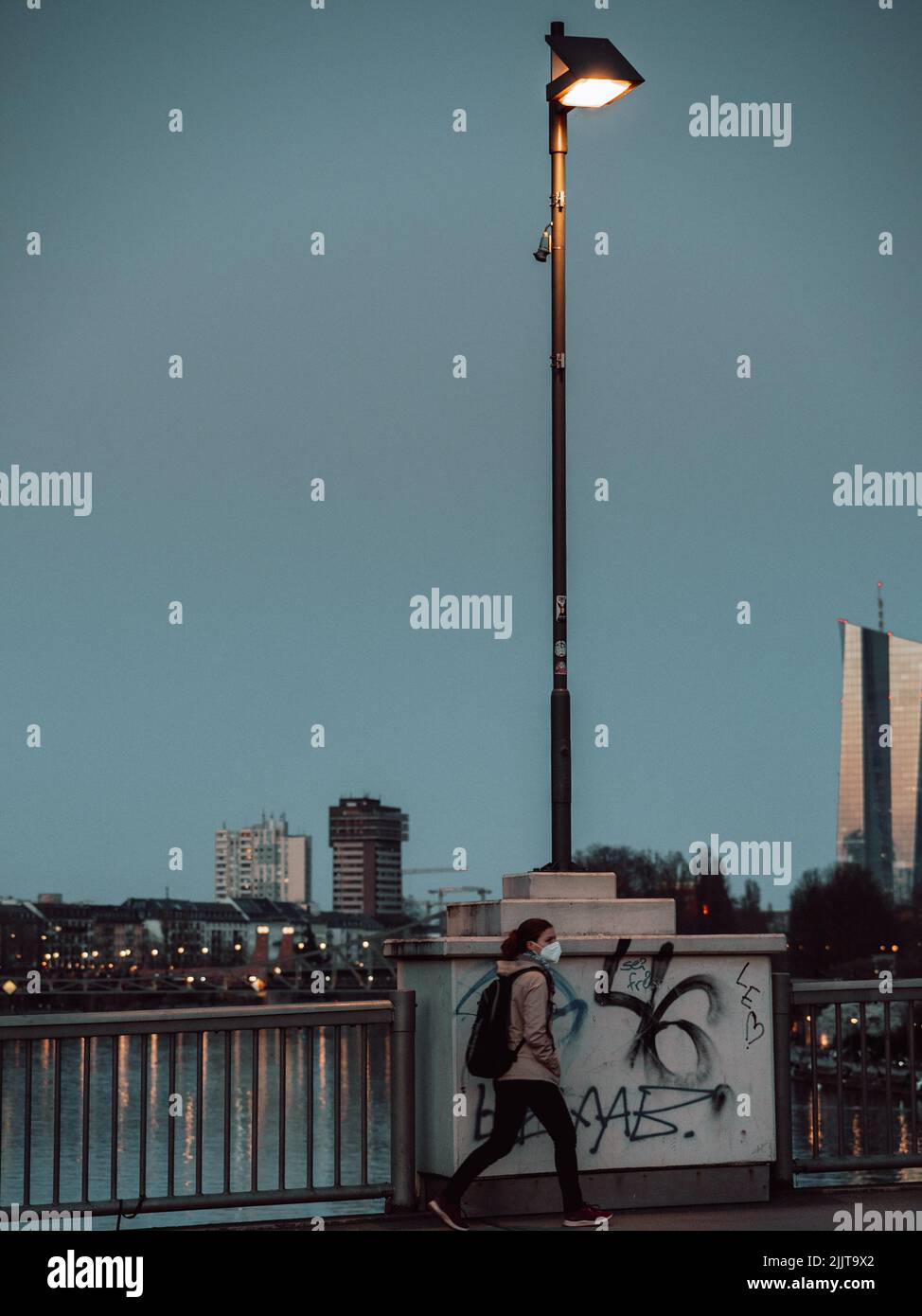 Una vista di una donna che cammina lungo la strada e gli edifici moderni sullo sfondo Foto Stock