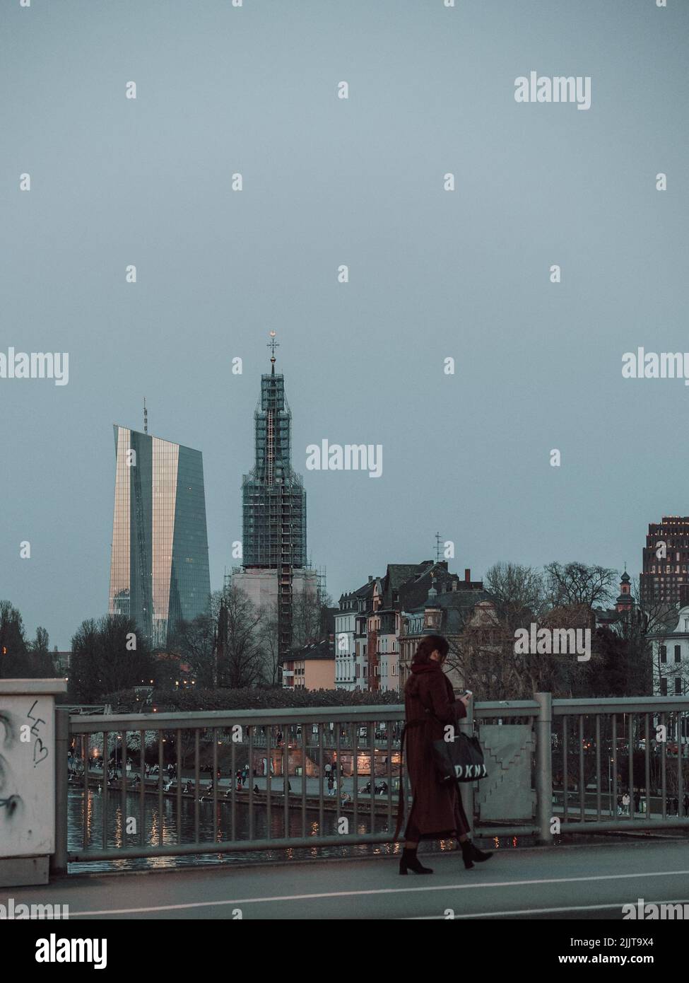 Una vista di una donna che cammina lungo la strada e gli edifici moderni sullo sfondo Foto Stock
