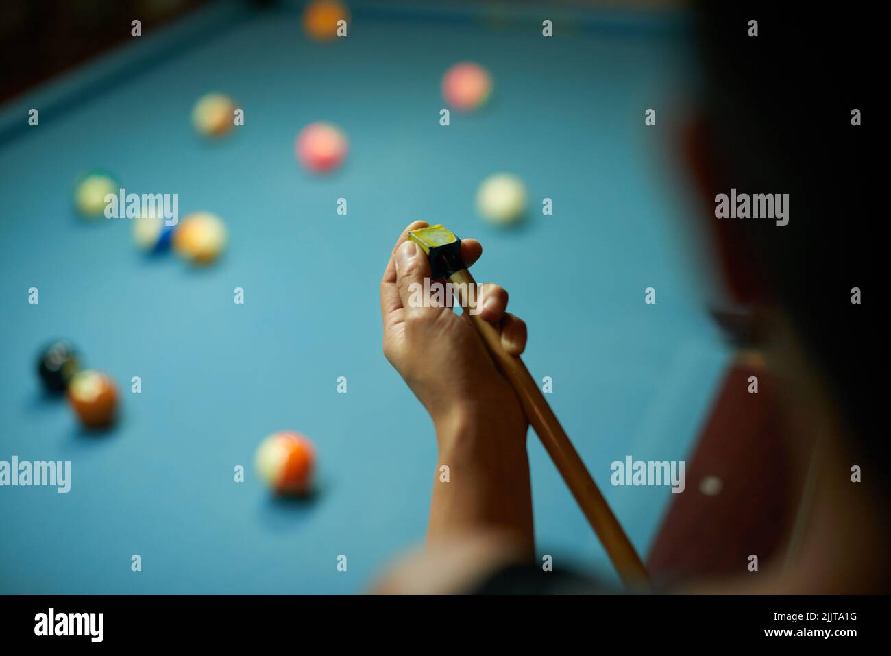 Mani di giocatore che cigolano cue in attesa del suo turno Foto Stock