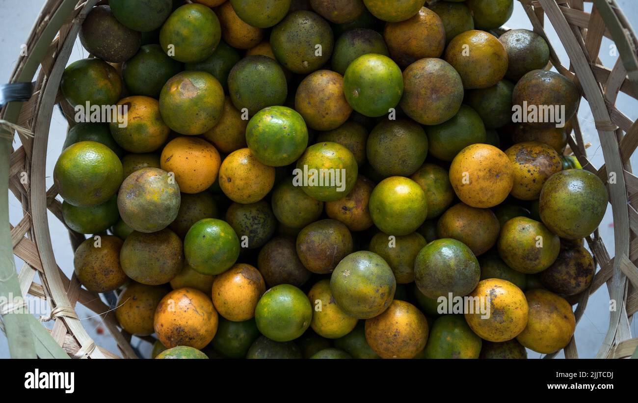 Top View pile di frutta fresca di arancia, vista dall'alto nel cestino per la vendita nel mercato delle verdure di Bali, Indonesia sfondo Texture o modello per mo Foto Stock