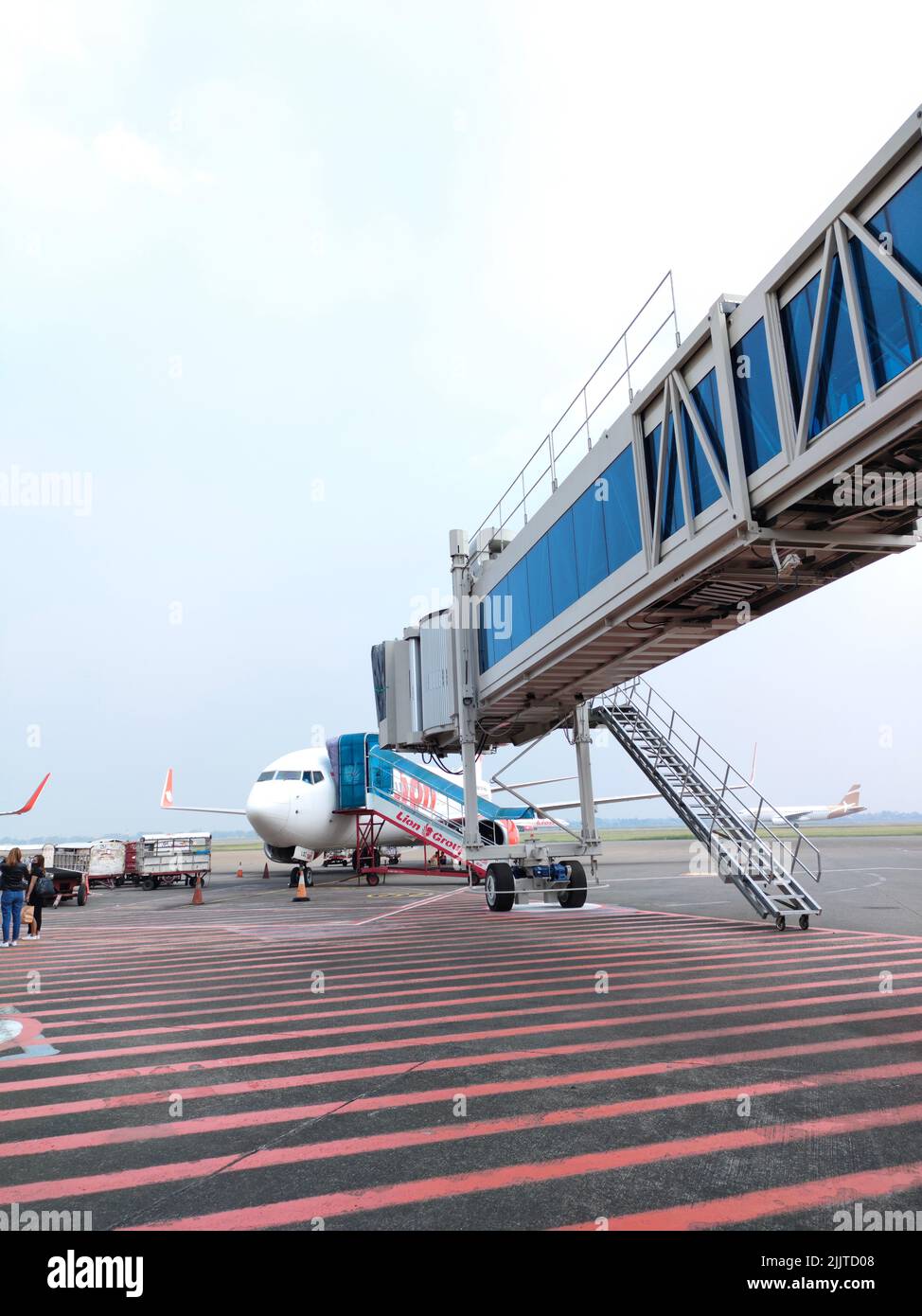 Un colpo verticale di un ponte aereo ad un aereo in un aeroporto quando i passeggeri si imbarcaranno a Jakarta, Indonesia Foto Stock