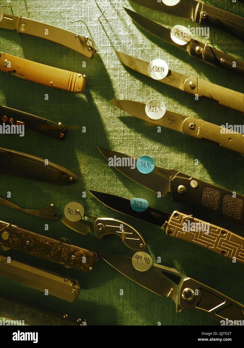 Un colpo verticale di coltelli diversi con le etichette di prezzo su di esso in un negozio di armi Foto Stock
