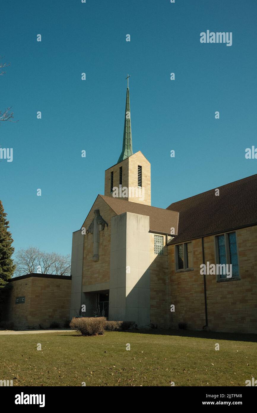 Un colpo verticale di una chiesa cattolica contro un cielo blu senza nuvole a Saint Paul, Minnesota Foto Stock