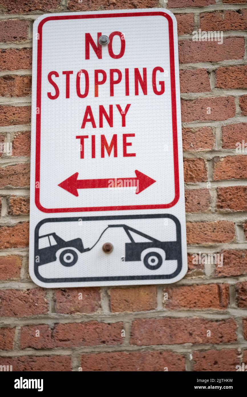Un cartello con la scritta no parking any time su un muro Foto Stock