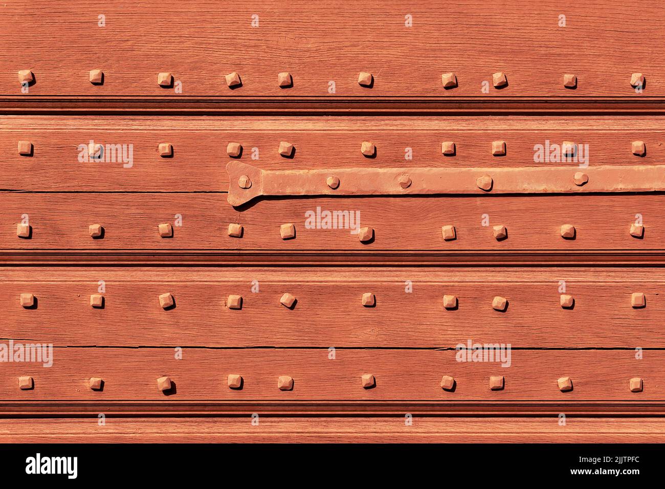Fondo in legno con chiodi porta magazzino vintage ed elemento in metallo. Architettura rurale. Foto Stock