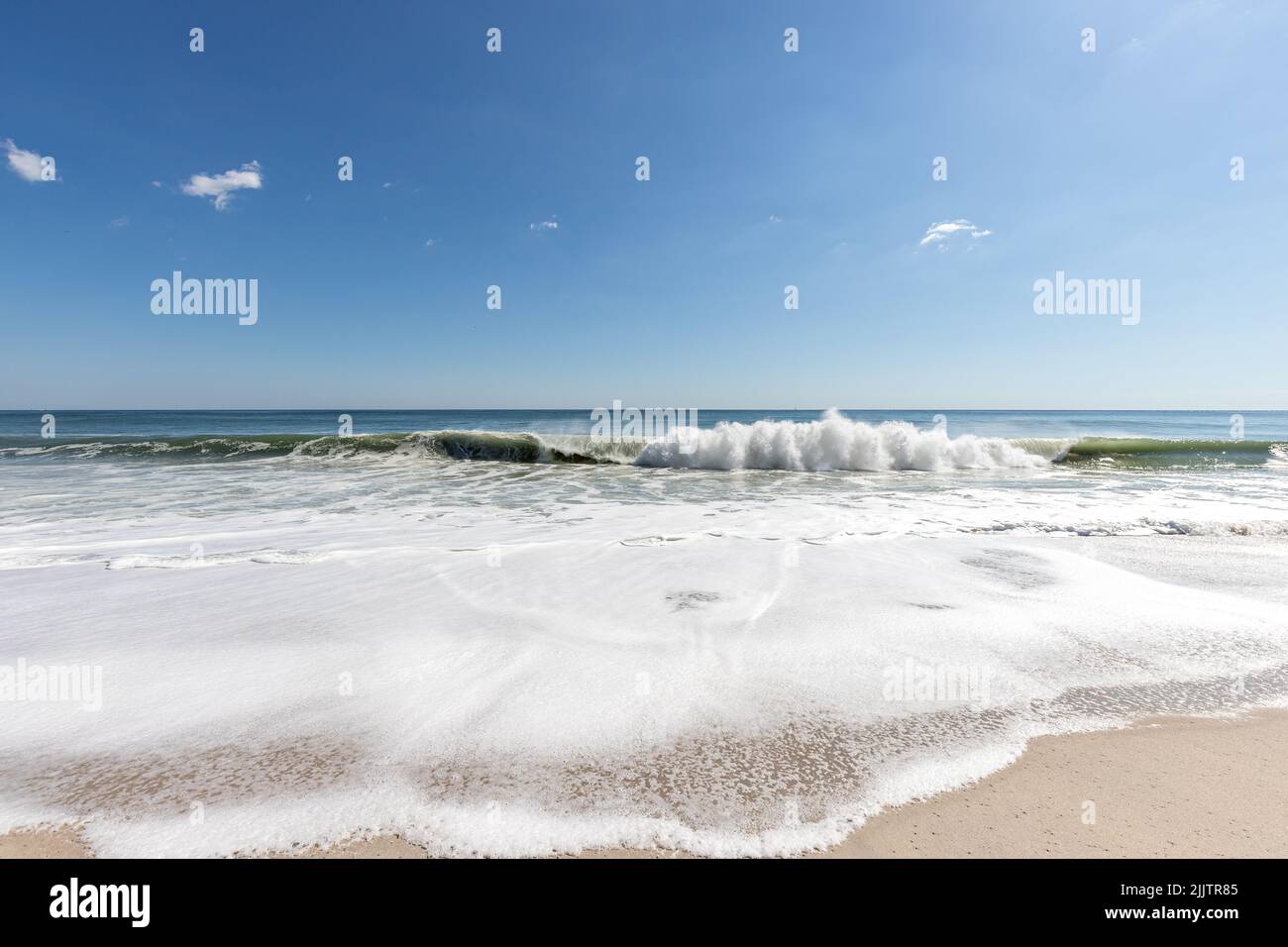 Una vista sulla spiaggia con onde bianche e cielo blu a Point Pleasant Beach NJ, USA Foto Stock