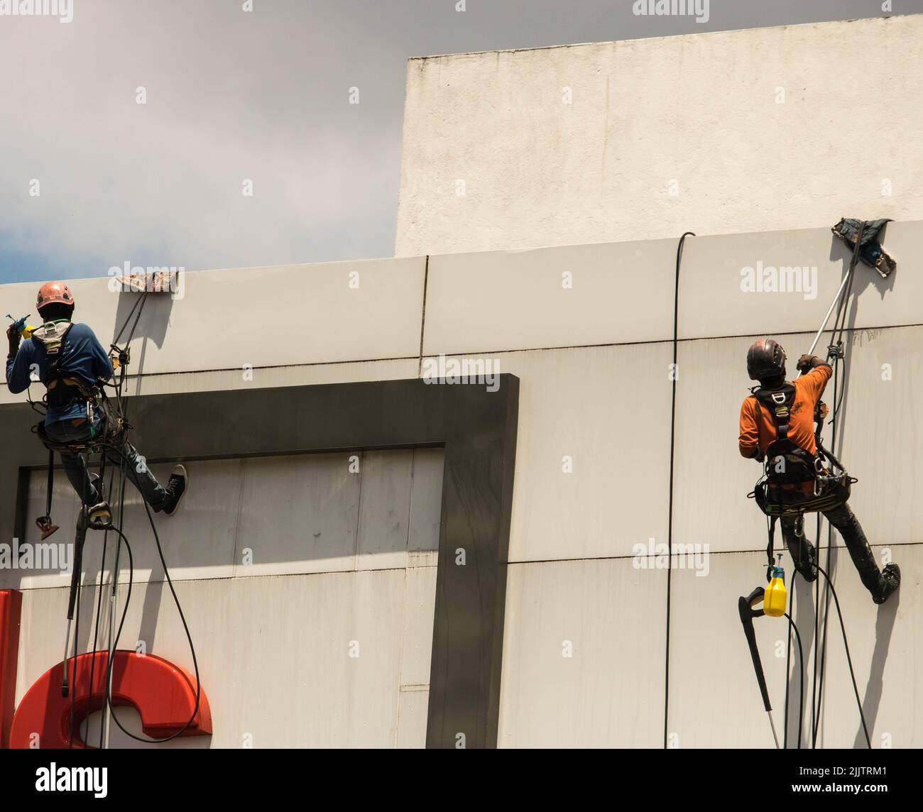 Uomini che pulgono un alto edificio Foto Stock