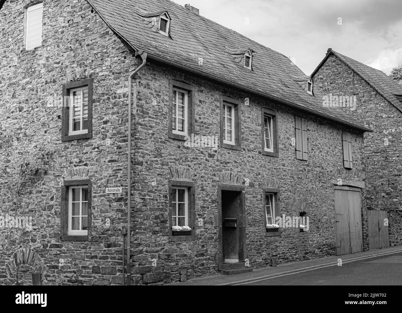 Una foto in scala di grigi di una piccola vecchia casa nel centro della città di Cochem Foto Stock