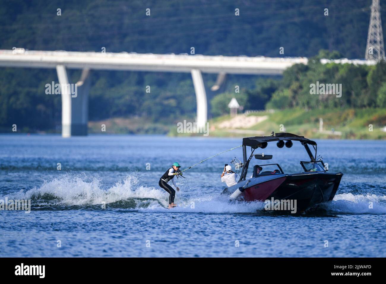 Nanning, la regione autonoma cinese di Guangxi Zhuang. 27th luglio 2022. Una donna si wakesurfs sul fiume Yongjiang a Nanning, Cina meridionale della regione autonoma di Guangxi Zhuang, 27 luglio 2022. La gente viene ai randelli di sport acquatici per godere il divertimento e la freschezza delle acque all'aperto durante i giorni estivi a Nanning. Credit: CaO Yiming/Xinhua/Alamy Live News Foto Stock