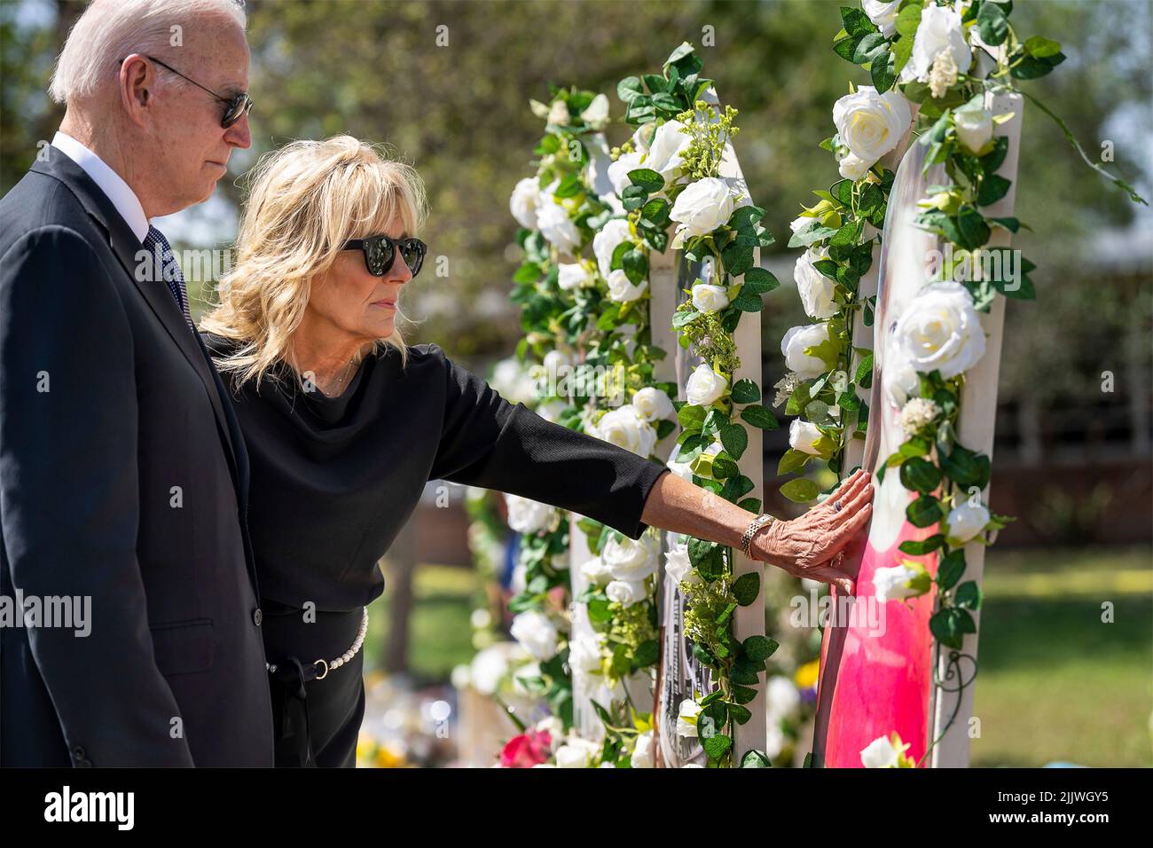 Uvalde, Stati Uniti d'America. 29 maggio 2022. Il Dr. Jill Biden, la First Lady statunitense, si avvicina per toccare una corona in un memoriale improvvisato mentre il presidente Joe Biden guarda fuori dalla Robb Elementary School, 29 maggio 2022 a Uvalde, Texas. La scuola è il luogo in cui un cannoniere ha ucciso 19 studenti e due insegnanti con un fucile d'assalto in stile militare. Credit: Adam Schultz/White House Photo/Alamy Live News Foto Stock