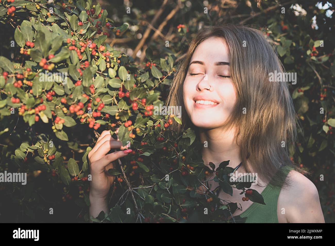 Donna che gode della foresta. Ritratto femminile nel tramonto bagliore al bosco. Immagine a toni. Foto Stock