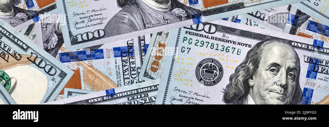 Banner di lotti di centinaia di dollari fatture. Un sacco di soldi sul tavolo per sfondo. Soldi degli Stati Uniti. Denominazione più grande Foto Stock