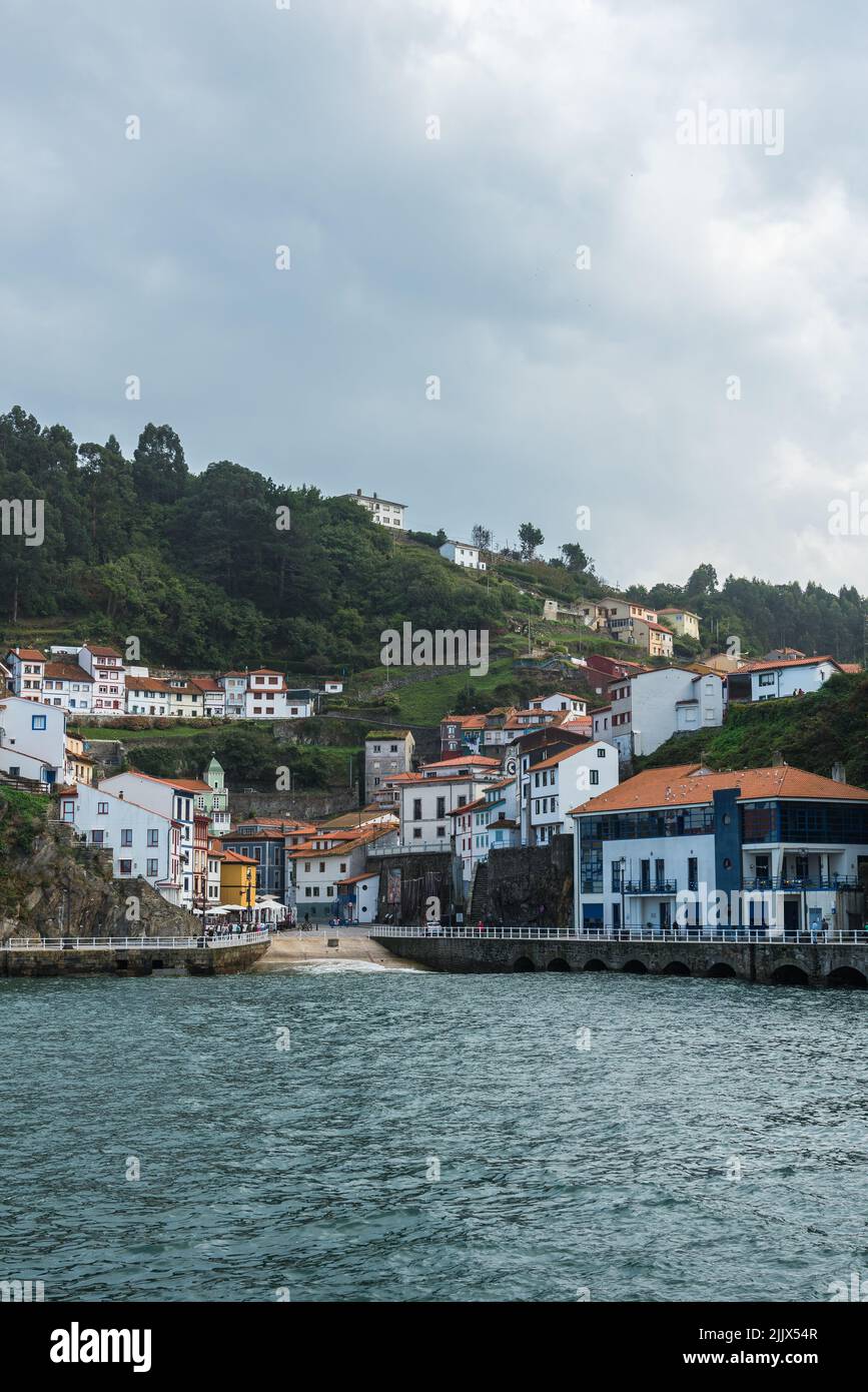 Edifici residenziali situati sulla riva con alti alberi verdi vicino ondeggiante acqua nella zona costiera della città in giorno d'estate Foto Stock