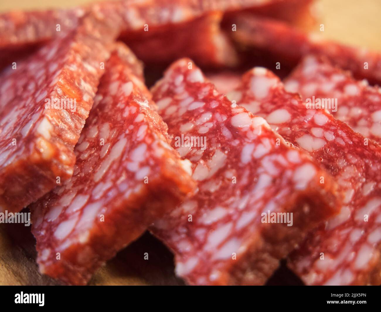 Vista macro su un pezzo di salsiccia di salame. Delizioso antipasto di carne. Foto Stock