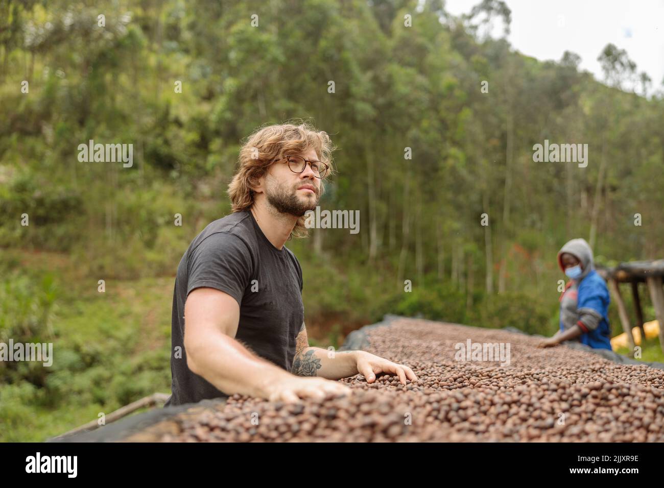 Giovane uomo che lavora alla fattoria del caffè, trattamento anaerobico Foto Stock