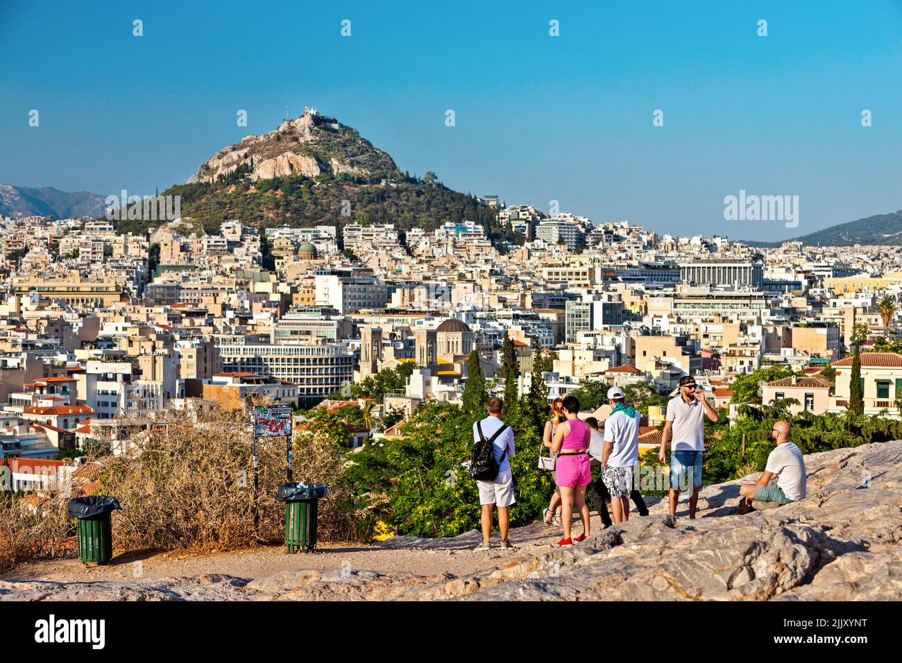 Ammirando la vista di Atene (Grecia) e della collina di Lycabettus dalla collina Areopagus ('Areios Pagos') sulle pendici dell'Acropoli. Foto Stock