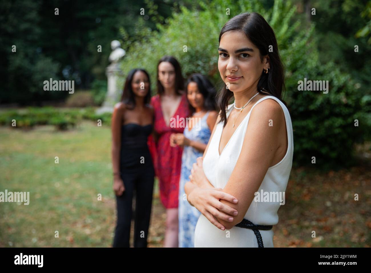 Primo piano di una ragazza caucasica isolata con i suoi amici di diverse etnie in background, concetto di donne e diversità Foto Stock
