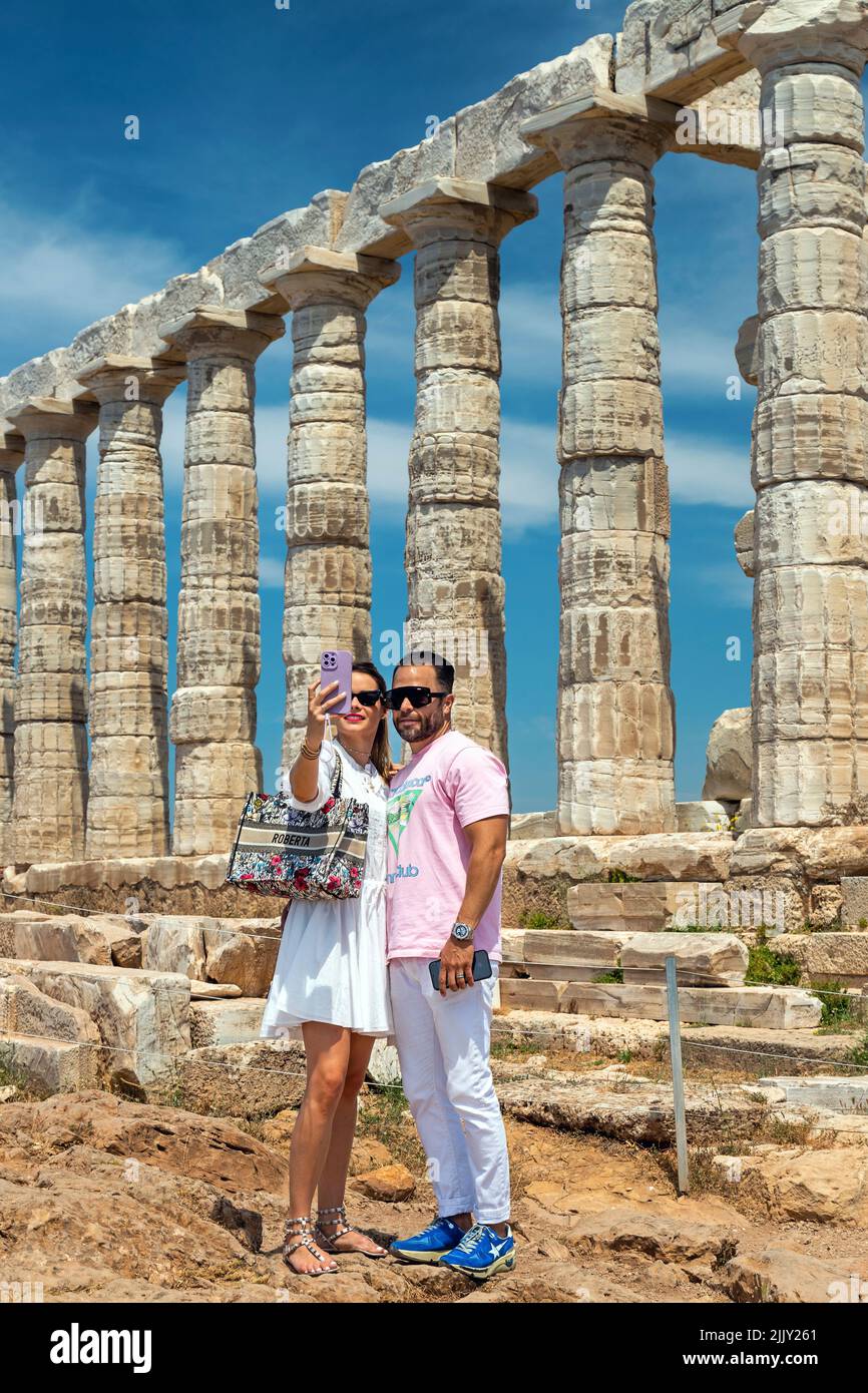 Bella coppia che prende un selfie di fronte al Tempio di Poseidone ('Nettuno') a Capo Sounion, Attica, Grecia. Foto Stock
