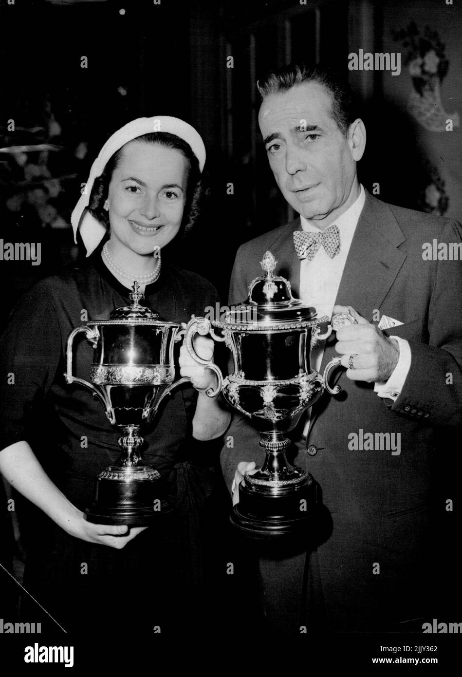 'Touch Guy' Bogart ottiene il Film Award - il ragazzo duro del film Humphrey Bogart è stato raffigurato al Savoy Hotel fino al giorno (Venerdì) con il Picturegoer Film Award 1952 che ha ricevuto oggi per la sua performance in 'The African Queen', che è stato votato il migliore da un attore maschile in qualsiasi film rilasciato nel 1952. Con lui è Olivia de Havilland, che ha ricevuto il premio per le attrici per conto di Susan Hayward, al quale è stato assegnato per la sua performance in 'Wwith A Song in My Heart'. Susan non è attualmente in questo paese, ma Humphrey in ***** un film qui. Maggio 15, 1953. (Foto di Reuterphoto). Foto Stock