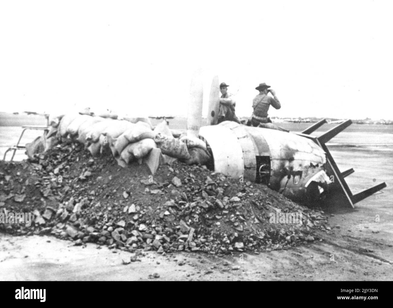 Makeshift Machine Gun Nest -- la didascalia su questa immagine approvata dal censore degli Stati Uniti legge, 'Solldiers sul lookout per gli aerei nemici in Makeshift Machine Gun Nest. Non vi è alcuna spiegazione o identificazione dei motori di aeroplano relitti nella figura. Scena è a Hickam Field, Hardhit dal giapponese attacco 7 dicembre. Marzo 12, 1942. (Foto di U.S. Army Signal Corps Photo). Foto Stock