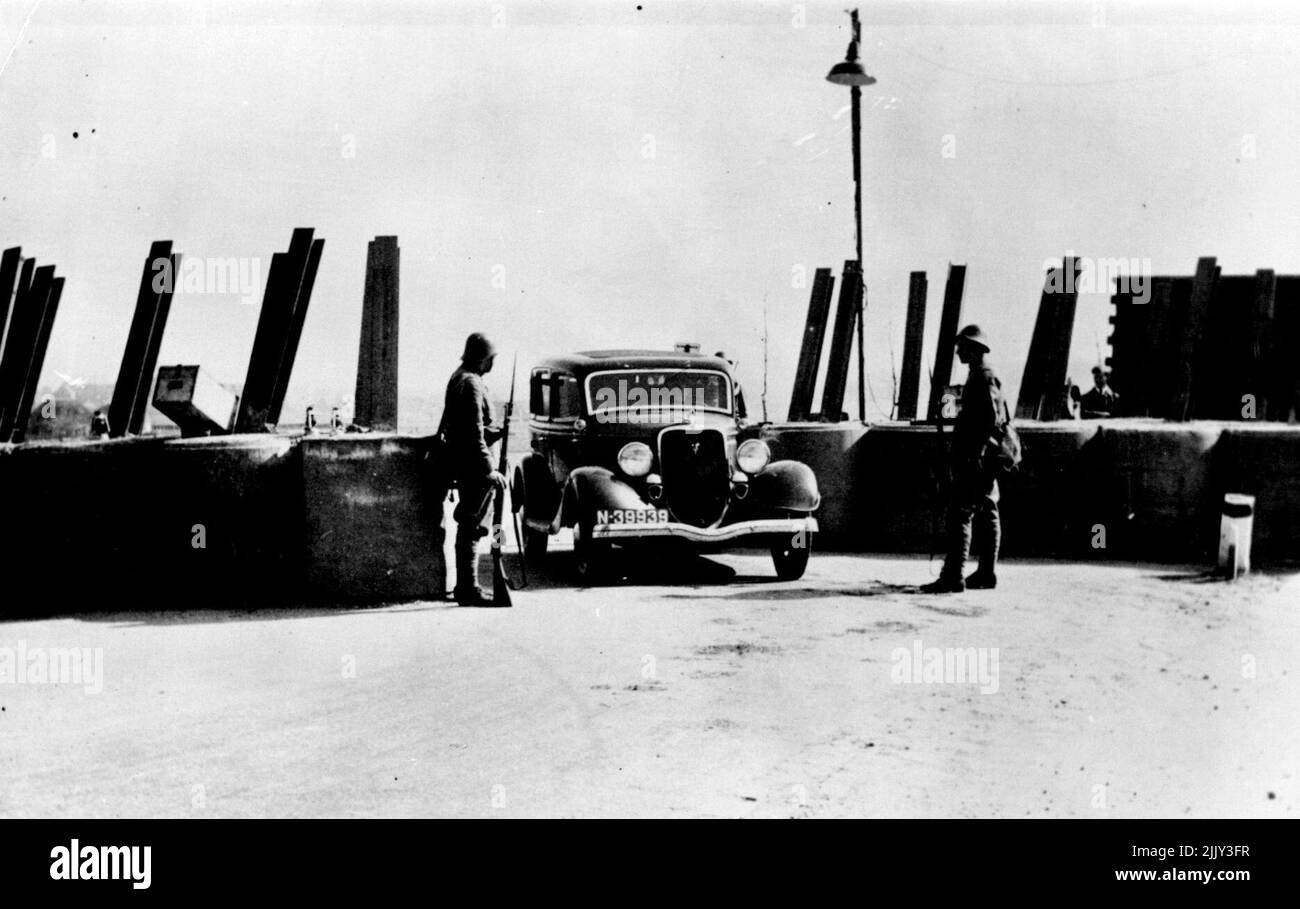 Holland Mans le sue difese -- truppe olandesi in guardia su una frontiera leggere 'dove in Olanda' rotaie di ferro incorporate in enormi blocchi di cemento come un anti-serbatoio di difesa tratto attraverso la strada, con piccole aperture per consentire il passaggio di una sola linea di traffico. Questi spazi vuoti possono essere chiusi con un preavviso immediato. Aprile 27, 1939. (Foto di Topical Press). Foto Stock