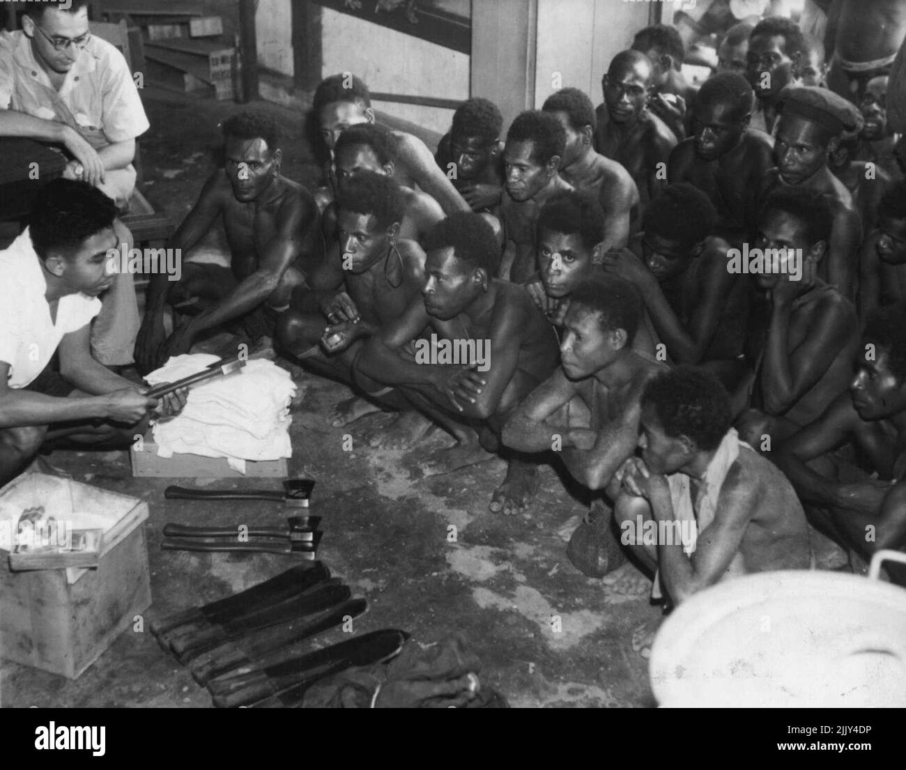 L'esercito australiano paga i nativi di Kai-Kai con denaro olandese. Con i contanti acquistano coltelli, assi, vestiti e tabacco al negozio cinese. Maggio 8, 1944. Foto Stock