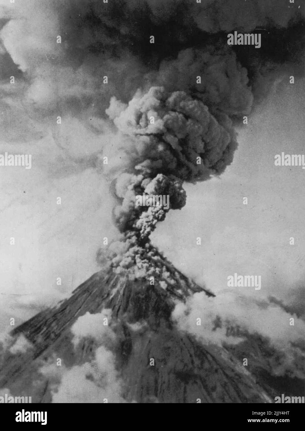 Il monte Mayon erutta -- Una colonna gigante di fumo sulfureo versa il monte Mayon come lava e rocce sono scagliate in cielo dal vulcano in eruzione sul Luzon meridionale nelle Isole Filippine, gennaio 14. La violenta 1947 erruption. Gennaio 19, 1947. (Foto di AP Wirephoto). Foto Stock