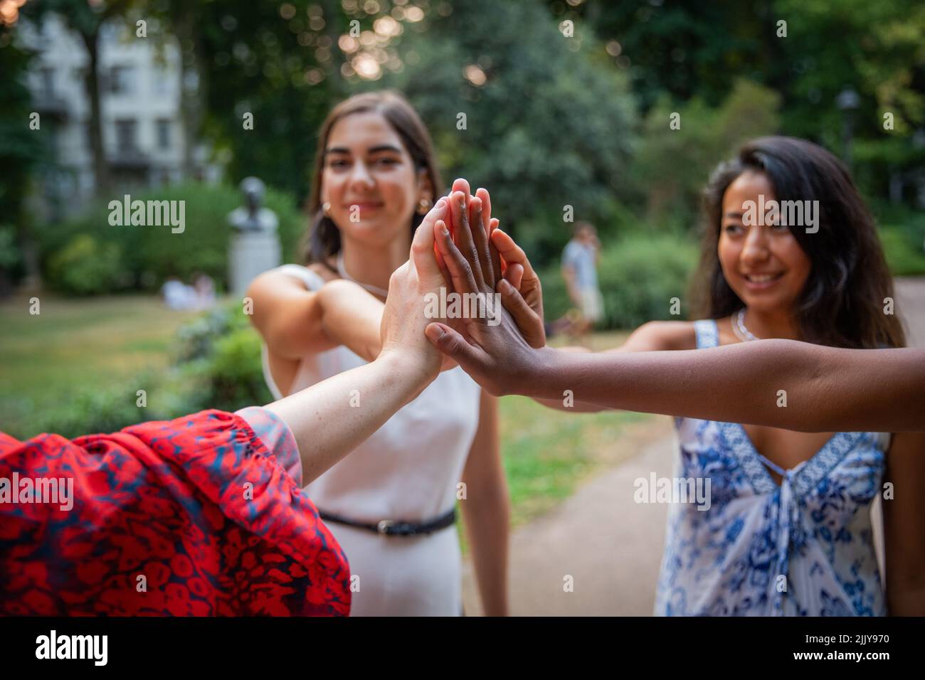 Primo piano delle mani di ragazze di diverse etnie che mettono le mani insieme come segno di integrazione e amicizia Foto Stock
