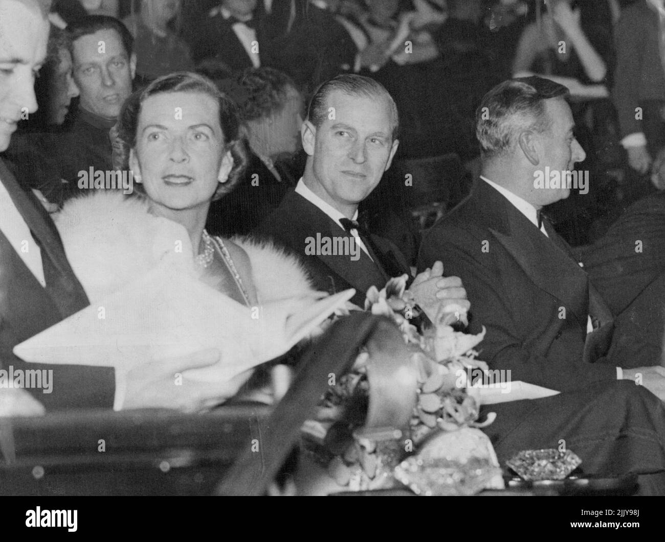 Duke con Mountbattens a Premiere - il Duca di Edimburgo seduto tra l'ammiraglio Conte Mountbatten di Birmania, il primo Signore del Mare, e la contessa Mountbatten nella Royal box alla prima mondiale del film 'Cockleshell Heroes' all'Empire Theatre, Leicester Square, Londra, a notte (Mercoledì). Il film racconta la vera storia di come una banda di 10 Royal Marines si sia fatta strada sul fiume Gironde in Canoes per saltare in aria la nave nazista che si era bloccata nel porto di Bordeaux. Il duca di Edimburgo è capitano generale dei Royal Marines. Novembre 16, 1955. (Foto di Reuterphoto). Foto Stock