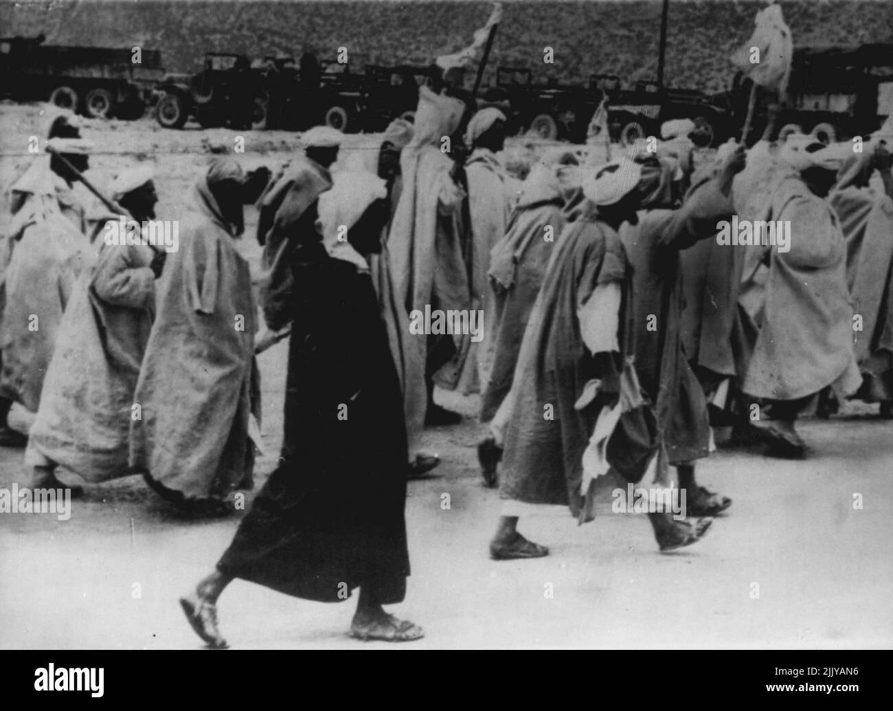 Spettacolo di ripetizione -- Berberi con bandiere bianche mentre marciano per arrendersi alle autorità francesi, 4 ottobre, dopo il massacro di ottobre 2 degli europei alla montagna marocchina nella città di Immouzer. I massacri precedenti in Marocco sono stati seguiti da simili rese. Ad una tale resa all'inizio di quest'anno. I tribesmen hanno massacrato il bestiame come sacrificio. Ottobre 6, 1955. (Foto di stampa associata). Foto Stock