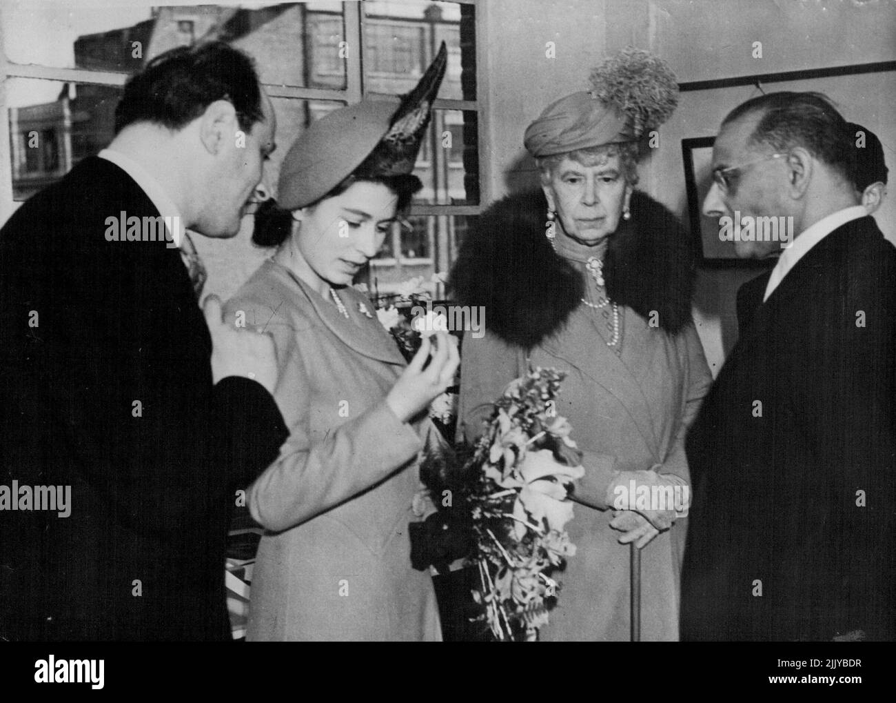 La principessa Elizabeth e la regina Mary visitano i taglierini del diamante -- la principessa Elizabeth è vista esaminare il suo diamante rosa di 54-carat che è stato dato lei come regalo di nozze dal Dott. H.T. Williamson, un canadese che possiede miniere di diamanti in madre, Queen Mary, sono in una fabbrica di taglio di diamanti a clerkenwell Green London, oggi 10 marzo, dove la pietra è tagliata. Aprile 08, 1948. (Foto di stampa associata). Foto Stock