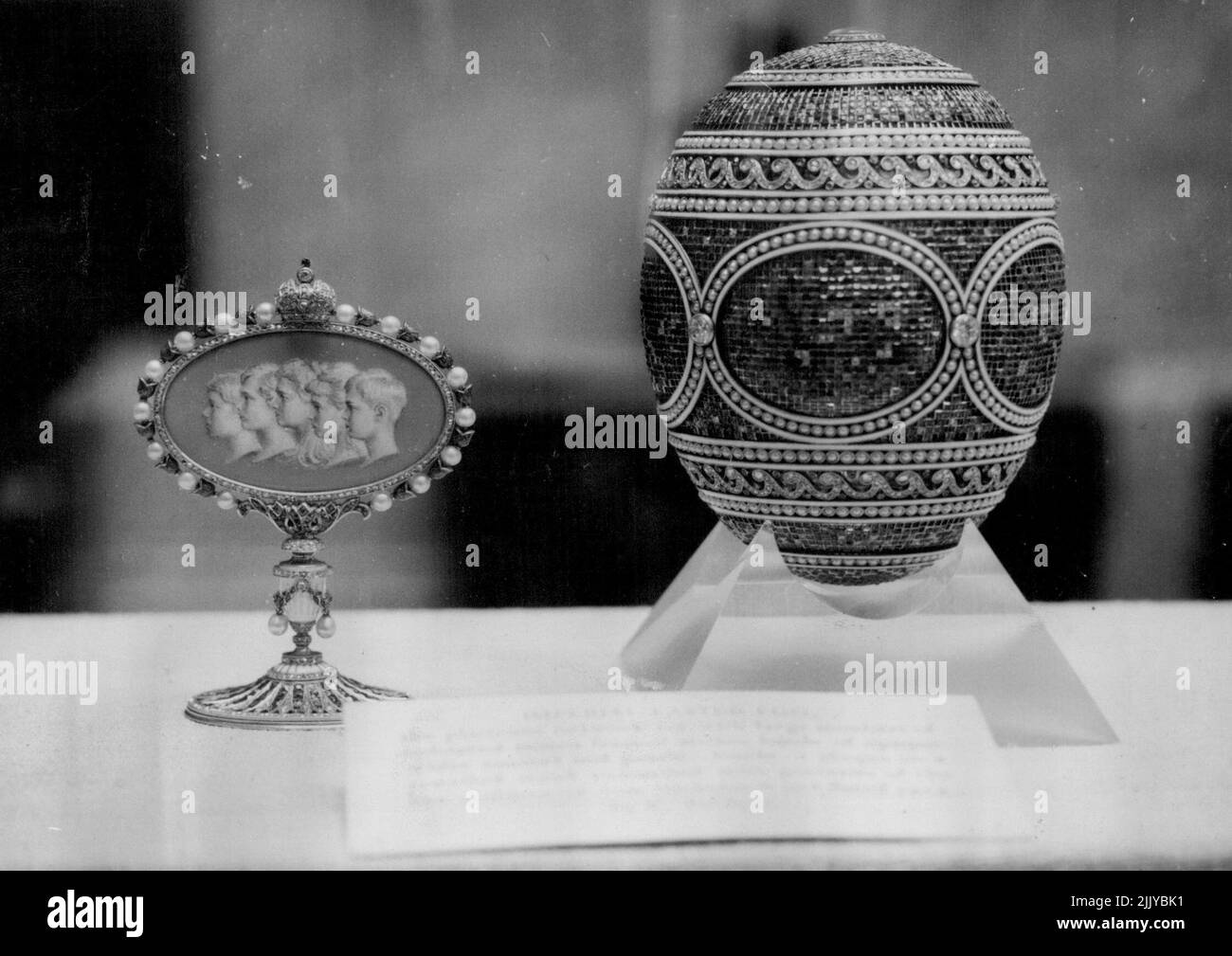 I tesori d'arte della Regina Maria di Pasqua più belli del mondo -- l'uovo di Pasqua di platino, oro, diamante, del gioielliere russo Carl Faberge è in uno dei casi esposti nella Mostra dei tesori d'arte della Regina Maria, che si svolge presso il Victoria and Albert Museum di Londra. Accanto ad esso si trova un gioiello che porta ritratti dei cinque figli di Zar Nicholas 11, donati dallo Zar alla Czarina a Pasqua 1914. La mostra si apre domani - compleanno della Regina Maria, che rimane aperta fino al 31 dicembre. Maggio 25, 1954. (Foto di Ronald Ockenden, United Press Photo). Foto Stock
