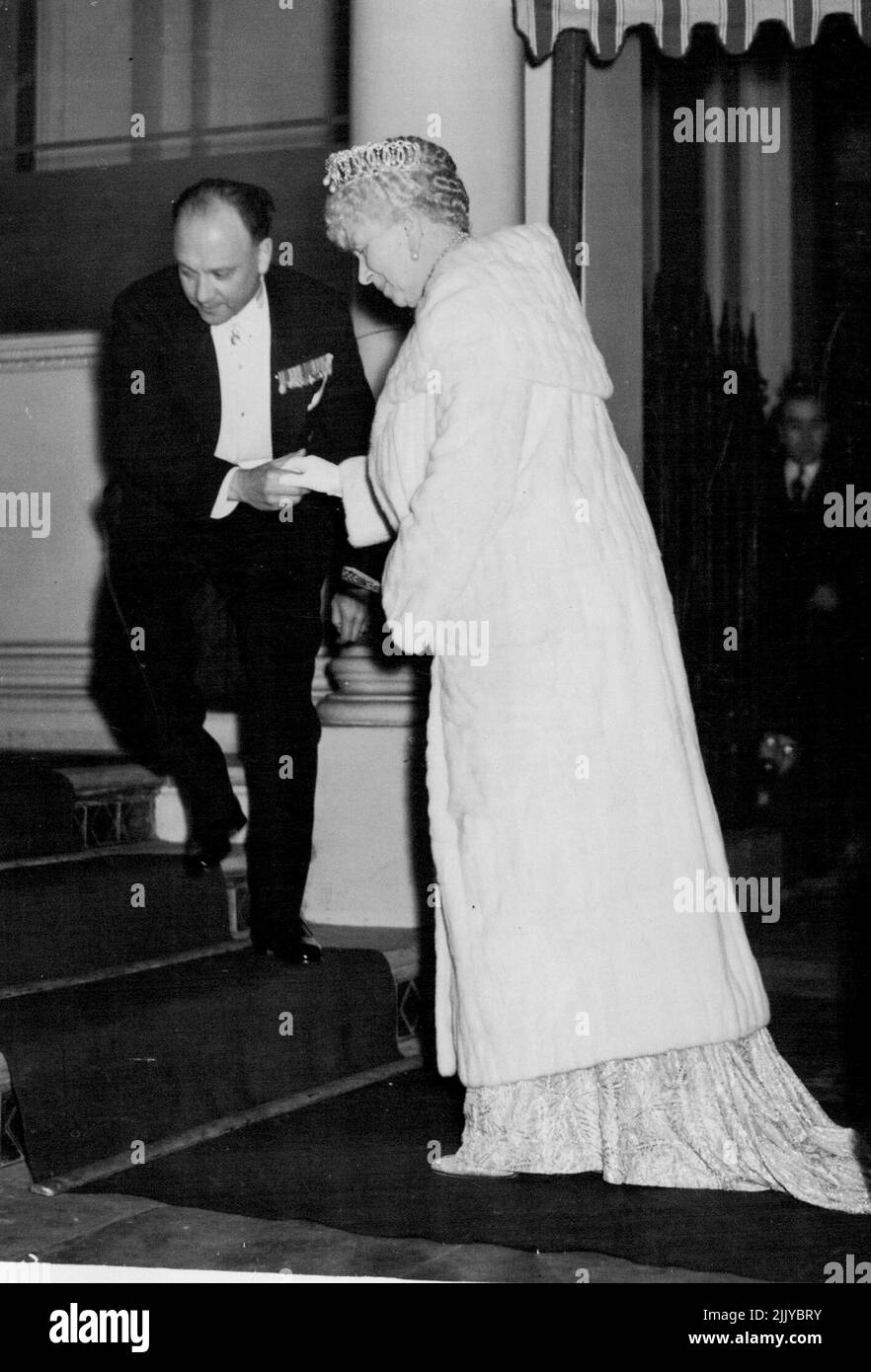Re Carol atti come ospite alla Royalty britannica -- la regina Maria essendo assistita sulle scale al suo arrivo alla legazione di Roumanian per la cena il 16 novembre. Re Carol di Roumania fu l'ospite della Legazione Roumaniana di Londra il 16 novembre, gli ospiti tra cui il re e la regina, la regina Maria, altri membri della famiglia reale, e diede loro una cena di sei portate, organizzata da Mme. Grigorcea, moglie del Ministro Roumaniano di Londra. C'erano 57 ospiti in tutto, seduti ad un tavolo a ferro di cavallo. Novembre 17, 1938. (Foto di stampa associata). Foto Stock